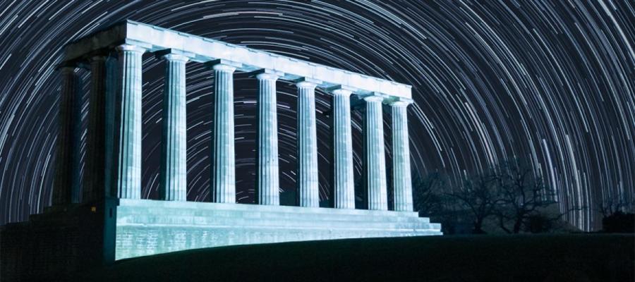 Composite image of Calton Hill with star timelapse in background