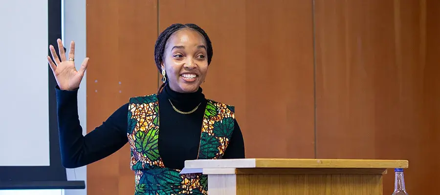 Young women with her hand raised giving a presentation