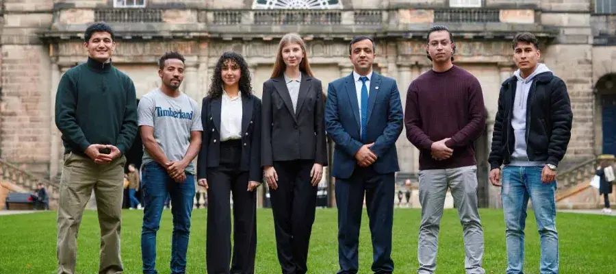 Seven people from Education Beyond Borders standing outside of the University's Old College.