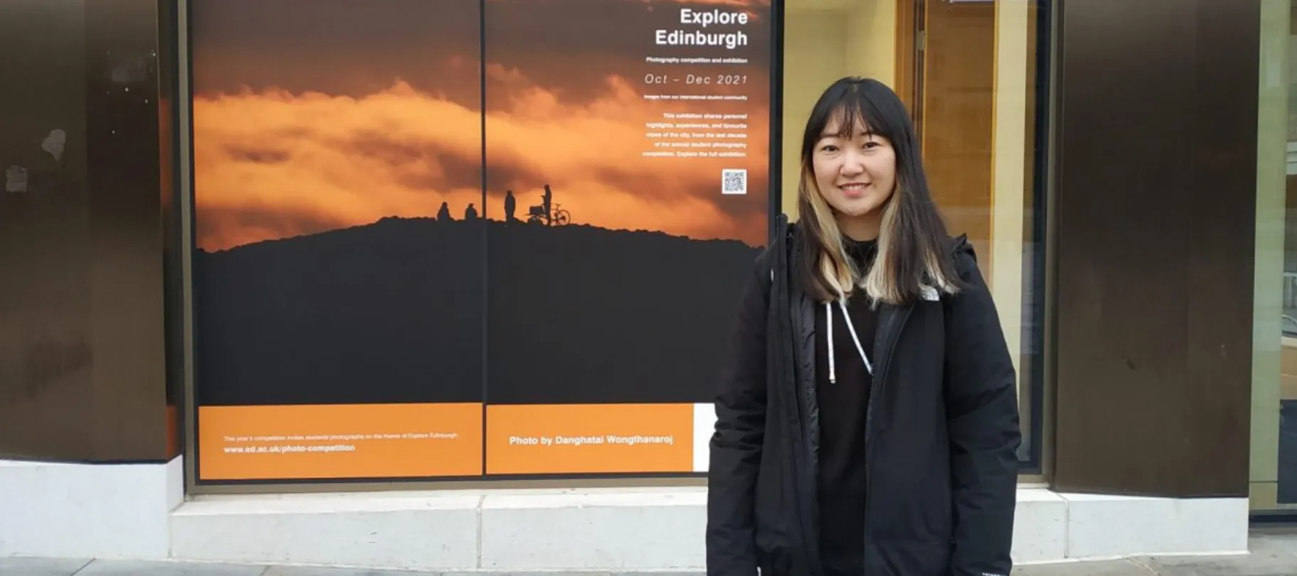 woman smiling in front of photography exhibition
