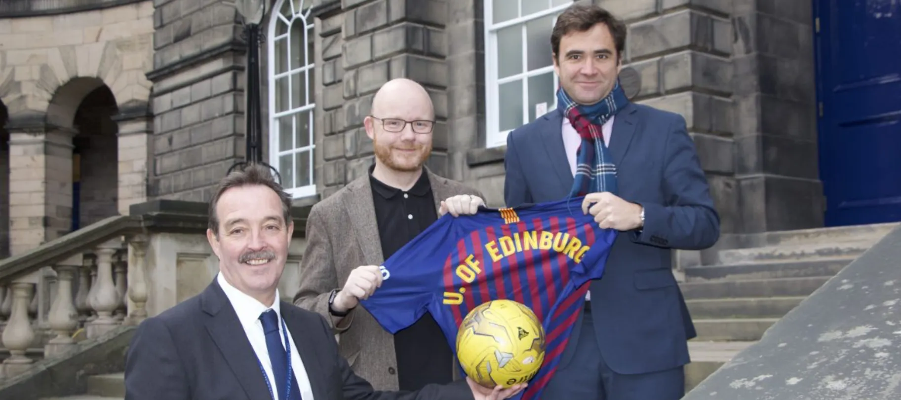 Partnership members posing with golden football