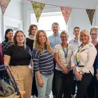 A group of adults standing in a room smiling at the camera.