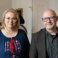 James Smith and Kseniia Smyrnova smiling at the camera.