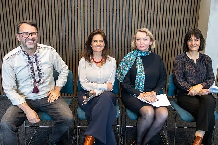 Four professionals sitting and smiling at the camera.