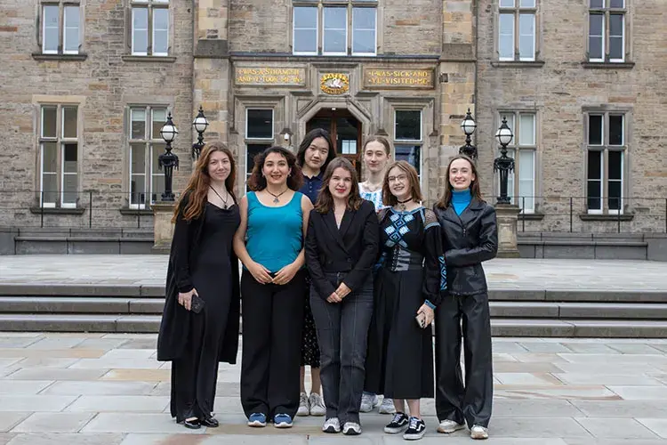Seven students standing in front of the Edinburgh Futures Institute.