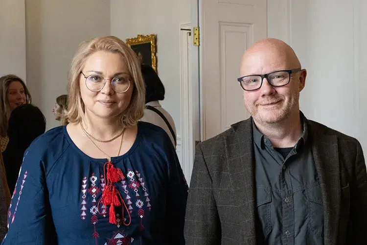 James Smith and Kseniia Smyrnova smiling at the camera.