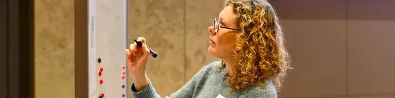 A women writing on a whiteboard