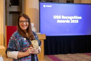 Inga Ackermann collects the Outstanding Student Experience USG Award at Playfair Library