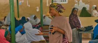 Saadatu Sulaiman standing and speaking to a group of people.