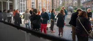 Professionals socialising in a large meeting room in KU Leuven.