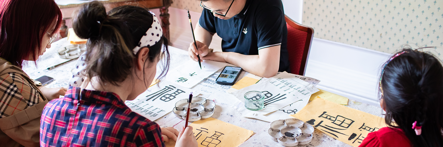 A group of people doing Calligraphy