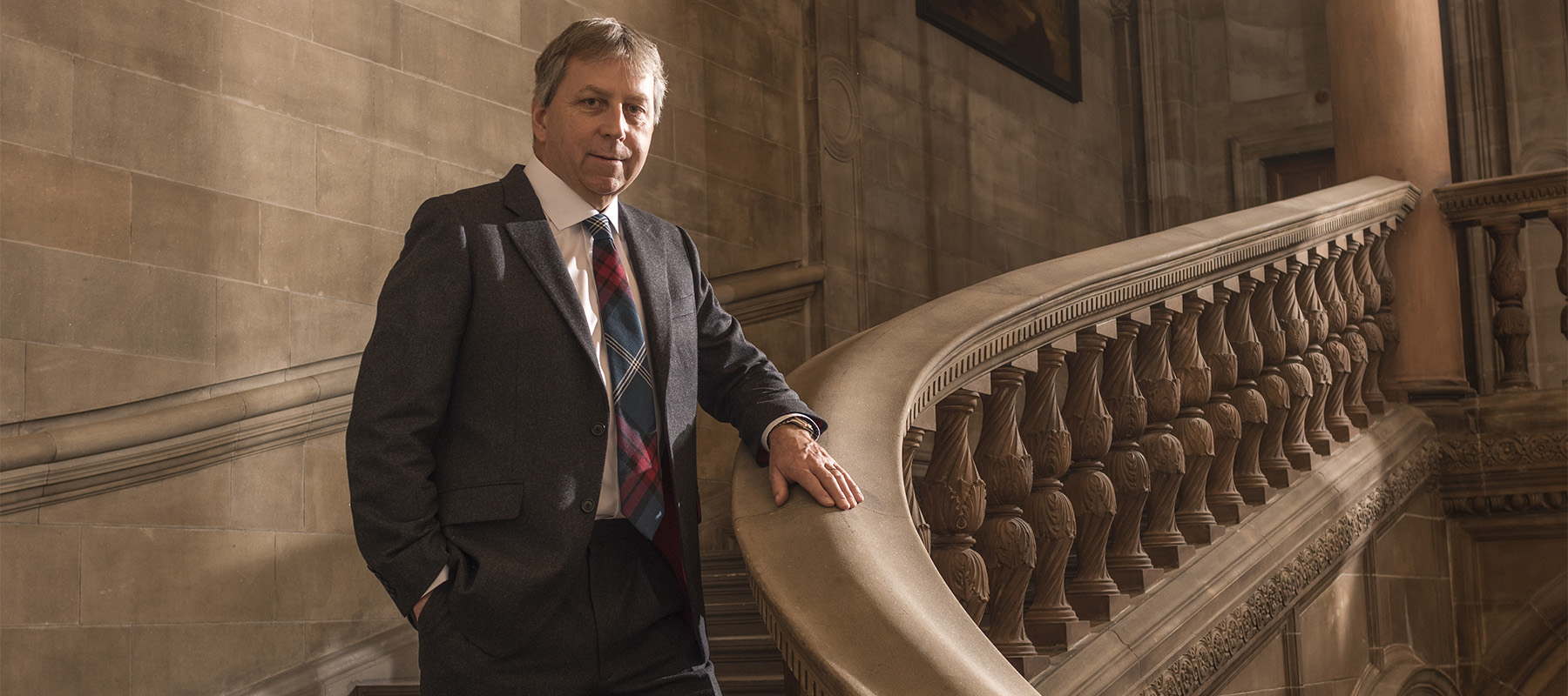 Principal Peter Mathieson stands in a staircase of McEwan Hall