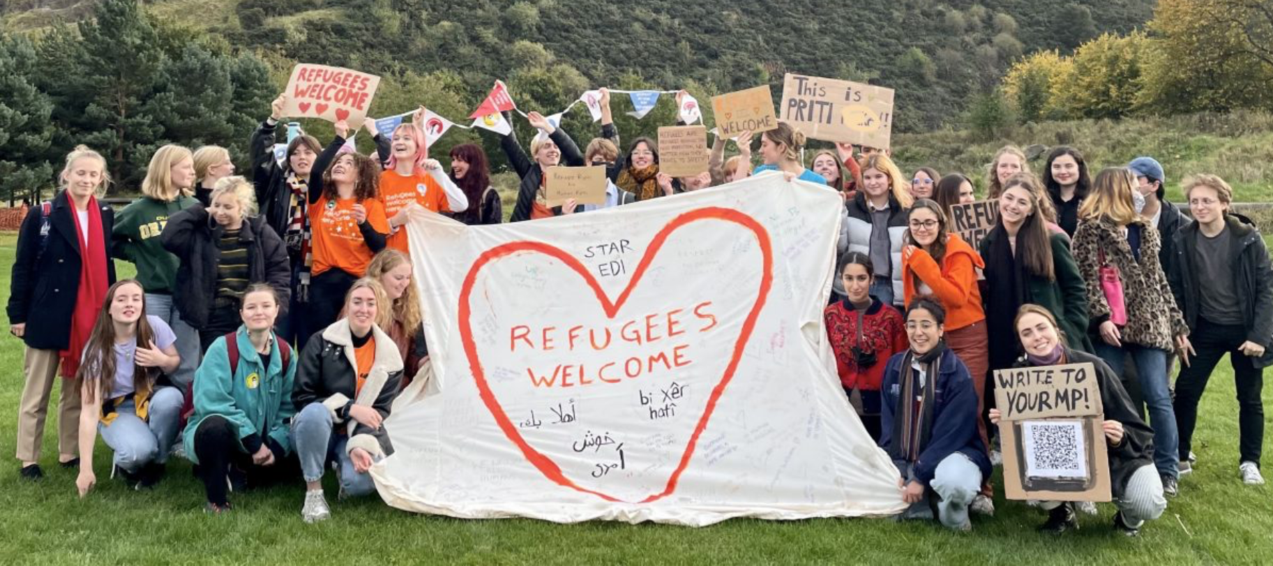 crowd holding welcome banners